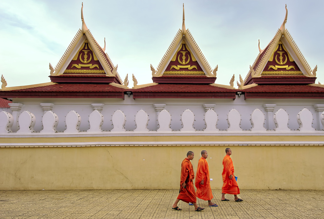 Monks stroll past the Royal Palace, Phnom Penh cambodia