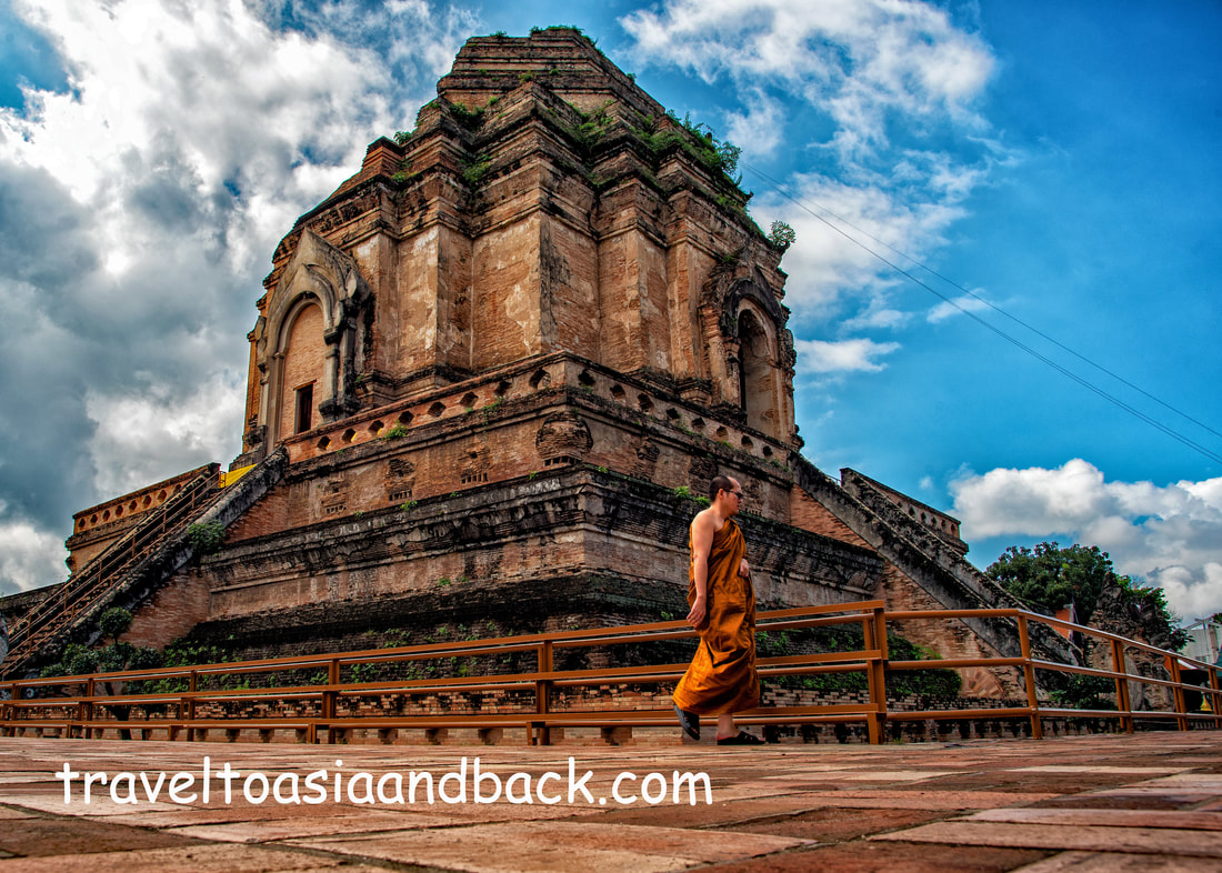 traveltoasiaandback.com - A monk strolls past Chedi Luang, Chiang Mai, Thailand